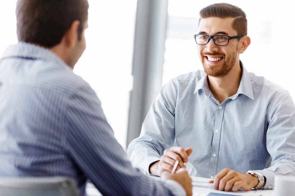 two smiling businessmen in a naturally lit office