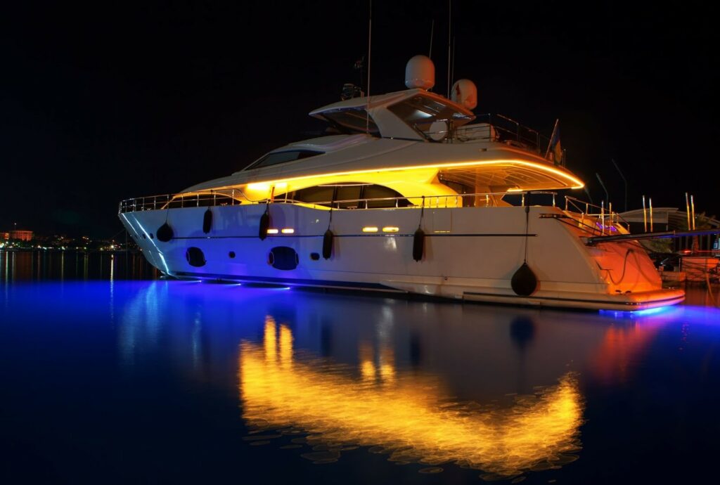 Boat in the water at night lit up by LEDs.